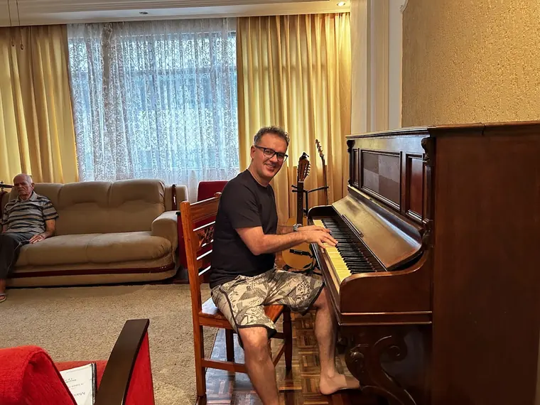 Fabricio Costa ao piano, olhando para a câmera durante o ensaio